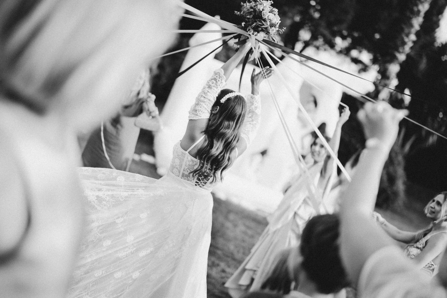 Noiva a lançar o bouquet, em preto e branco