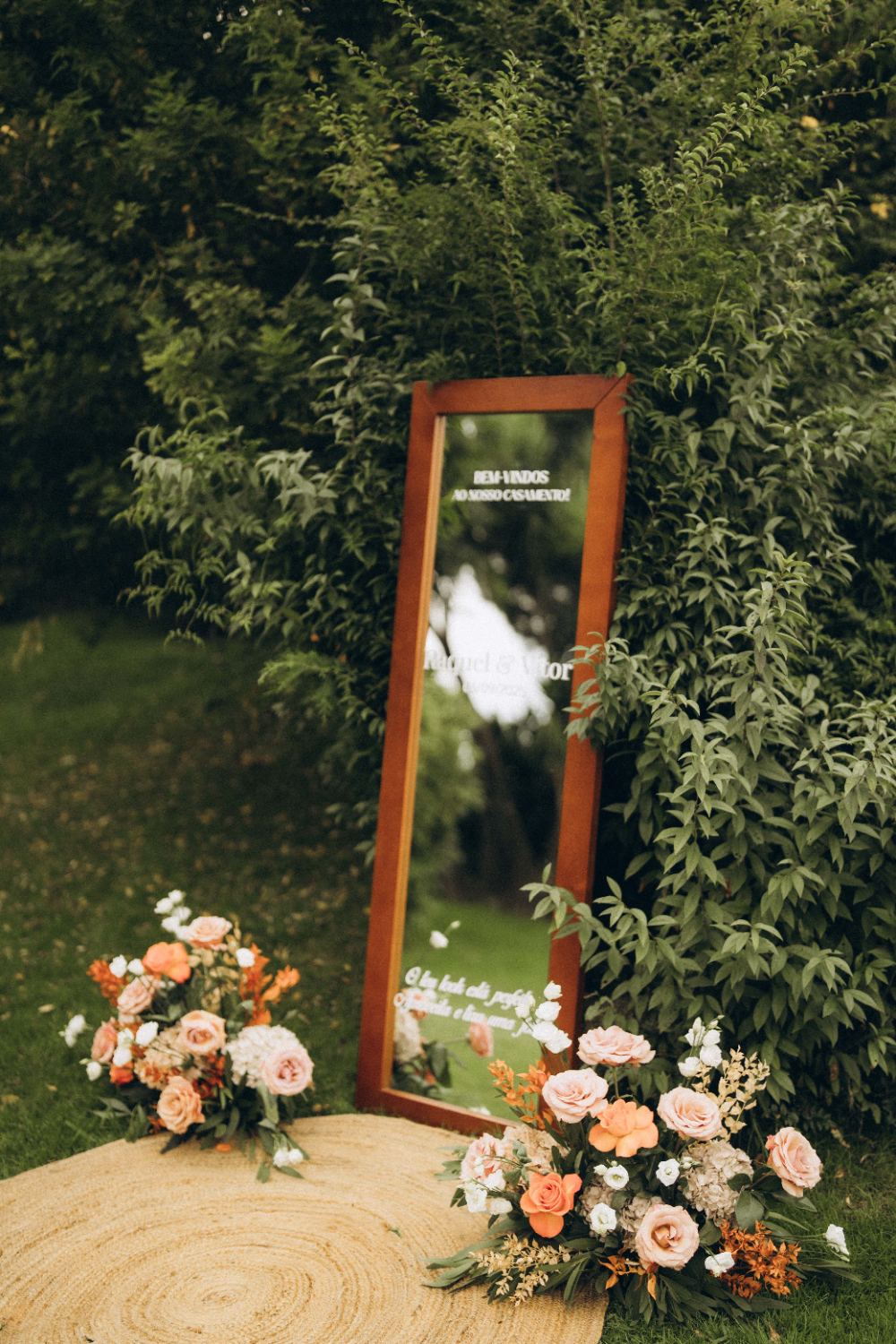 Espelho de boas-vindas com arranjos florais à entrada do casamento
